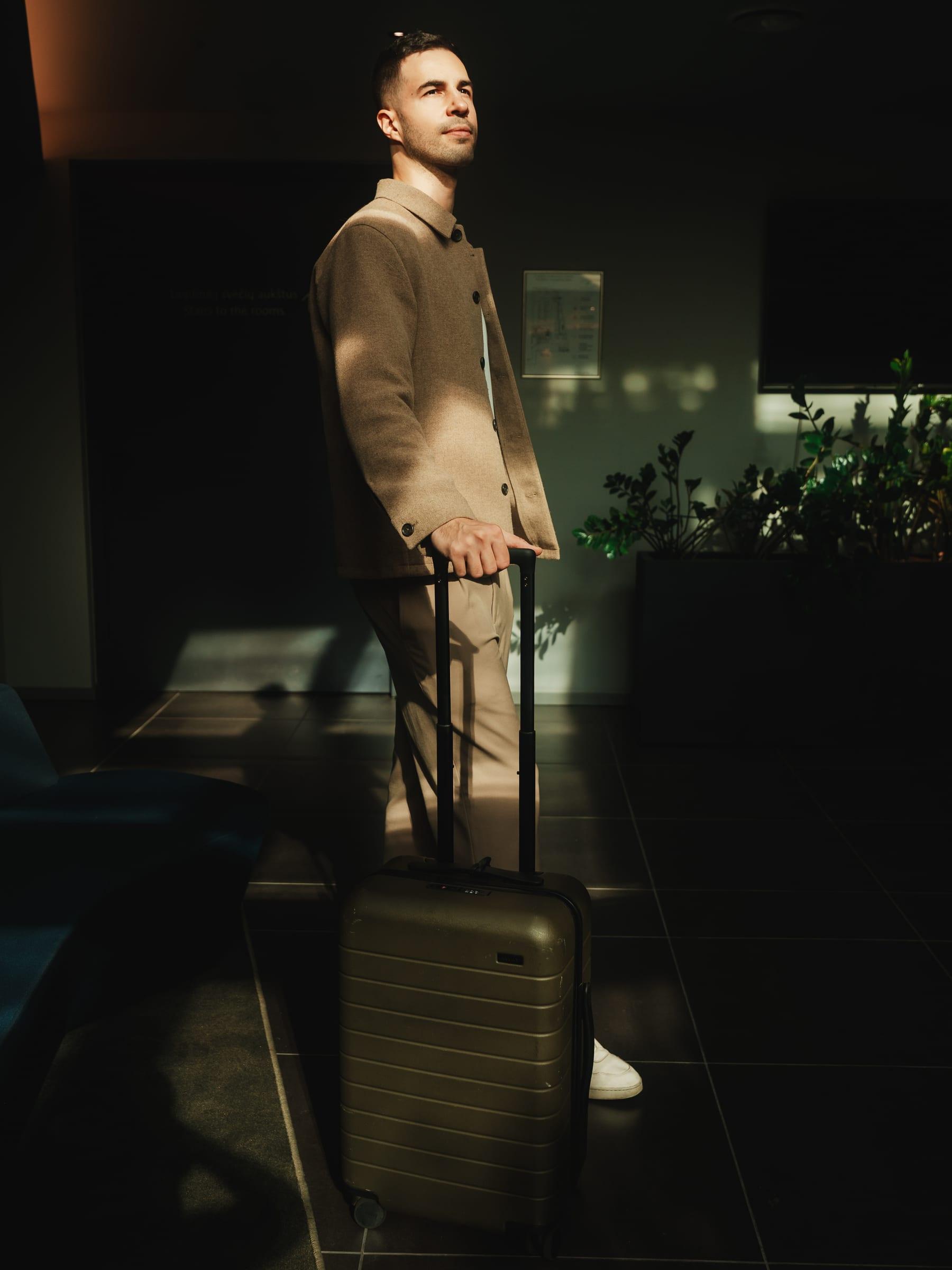 Setting up a suitcase mark in a shaft of light across the lobby floor