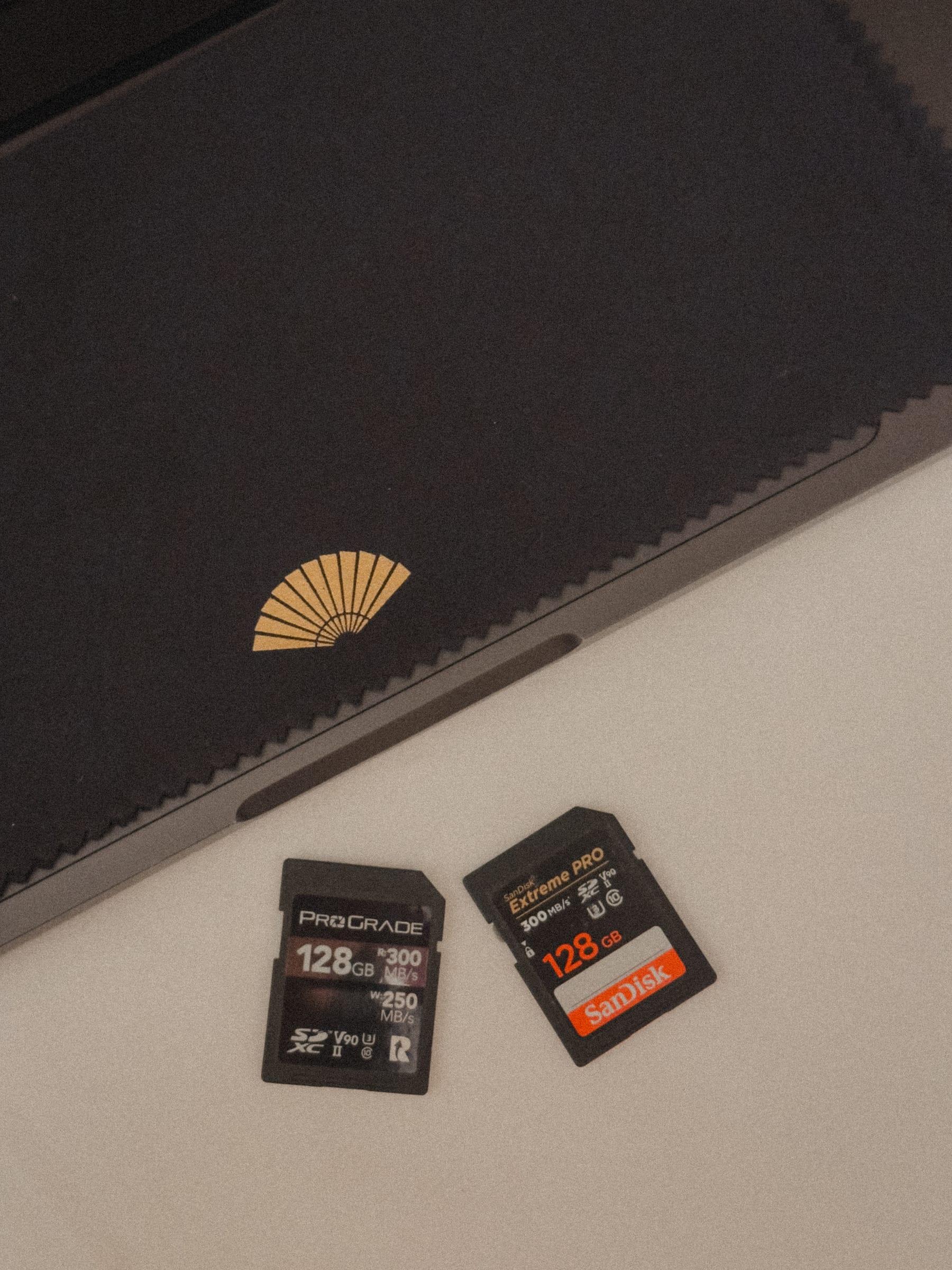Two cards out on the hotel notebook, the fan blocked in gold beside them