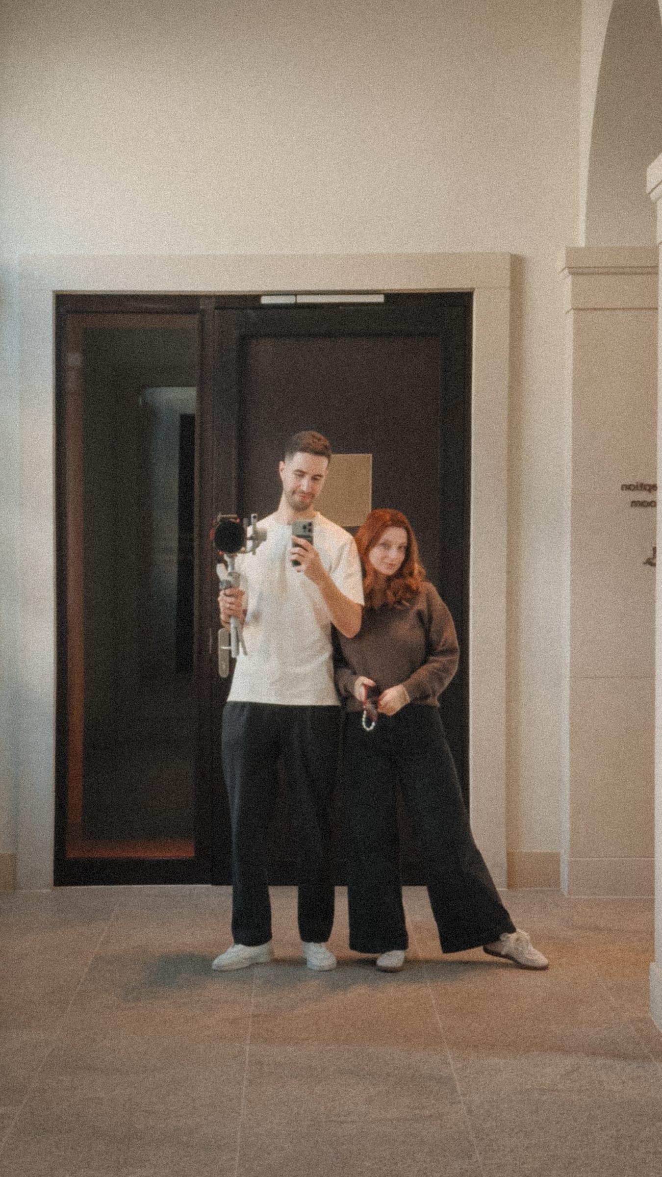 The two of us caught in the glass of the hotel door, camera up
