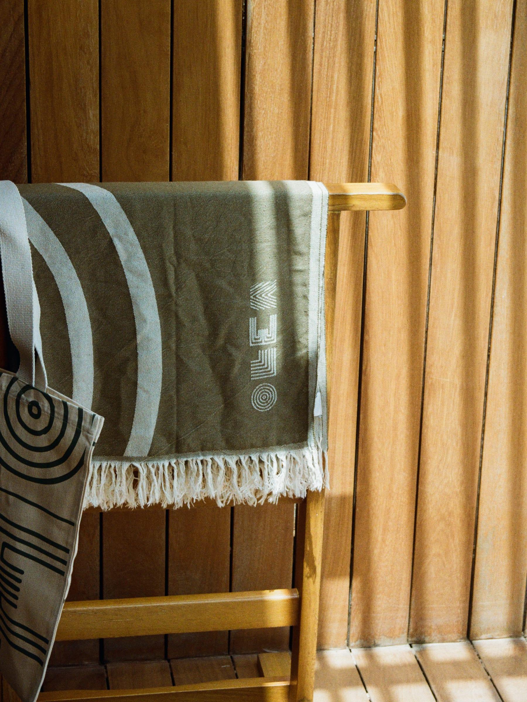The house towel folded over the timber rail with the sun coming through the slats