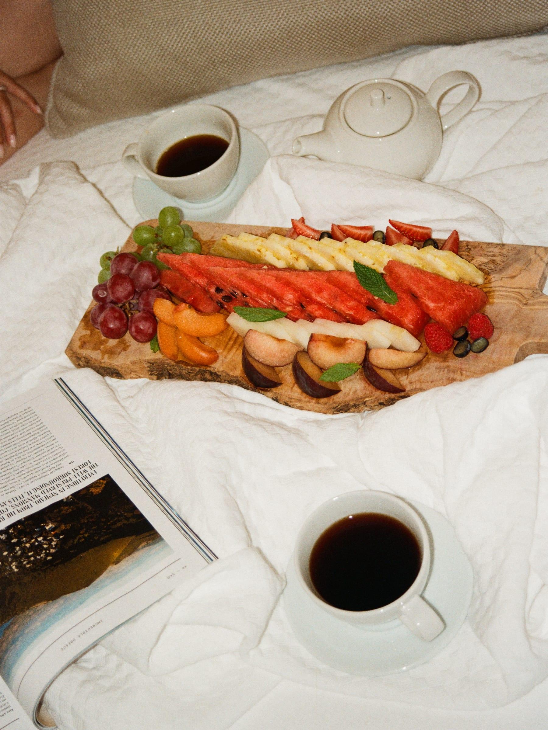 Breakfast brought to the bed: a long board of fruit and pastries and two coffees